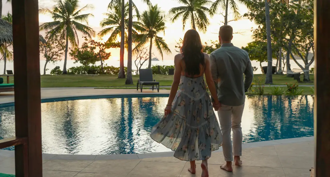 A couple overlooking the pool at Lomani Island Resort & Spa.