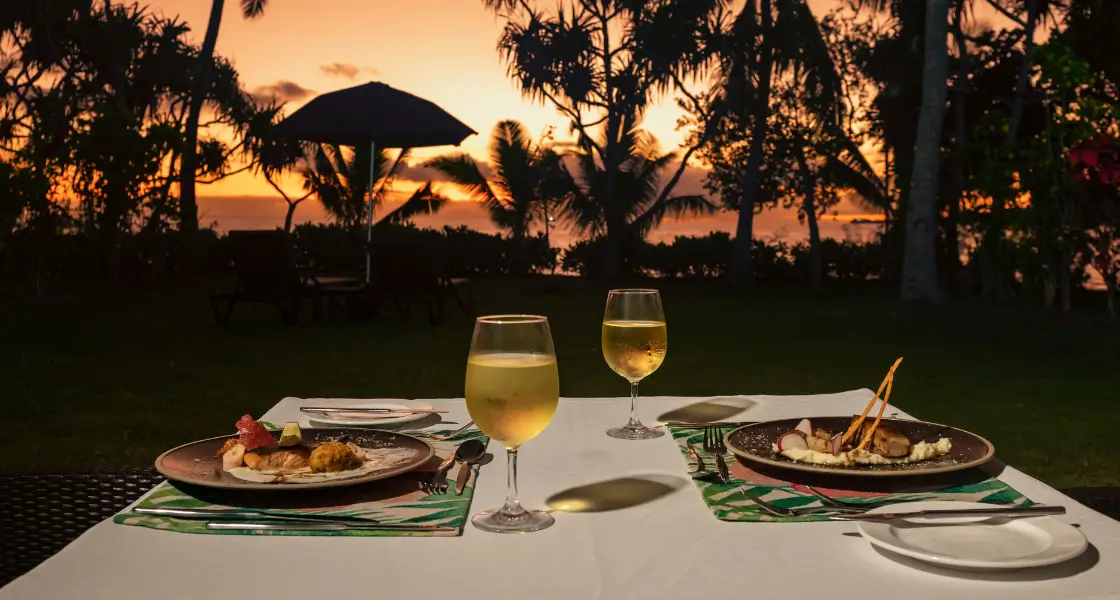 A private dining table overlooking the ocean at sunset