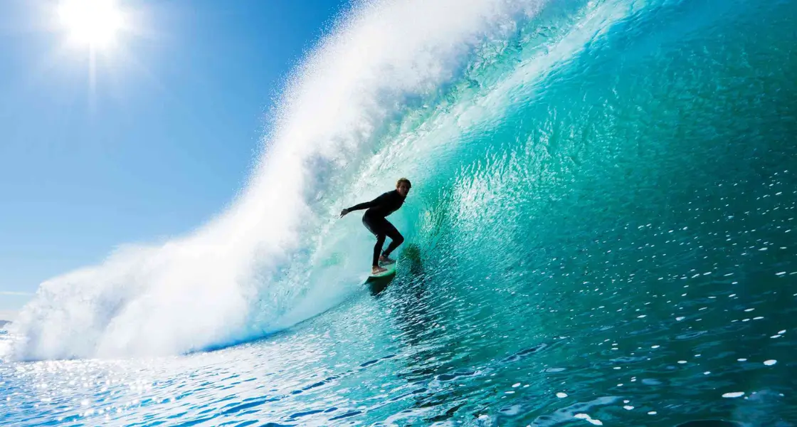 A surfer catching a wave at Cloudbreak, Fiji