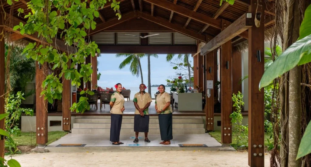 Three Lomani team members standing together at the arrivals bure ready to warmly welcome guests