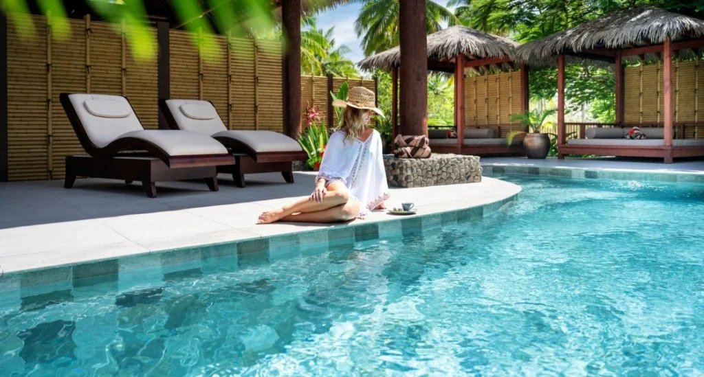woman relaxing sitting poolside gazing at the turquoise water at Lomani Spa